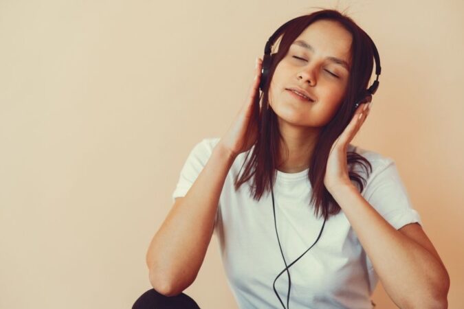 Une jeune femme écoute de la musique avec un casque, profitant d'une promo musique.