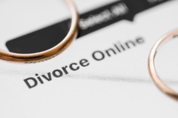 Deux alliances en or posées sur un document officiel affichant le texte "Divorce Online".