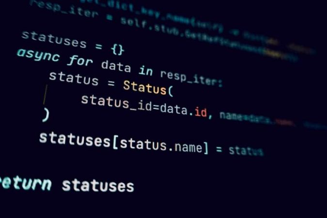 Un plan rapproché montre des lignes de code informatique Python asynchrone sur un écran sombre.